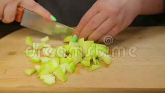 一个女人用一把刀把一个绿色的苹果切成小块视频的预览图