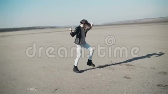 一个十几岁的女孩穿着黑色夹克在露天跳舞风中的头发视频的预览图