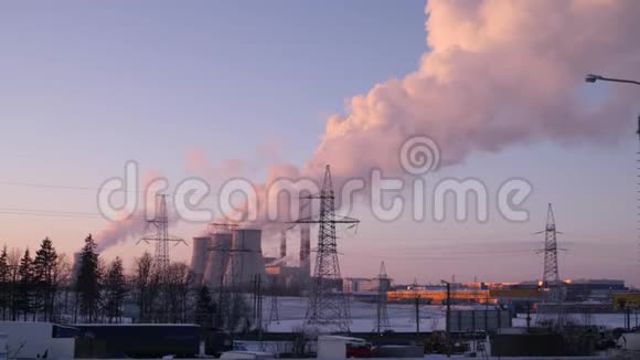 从一个4K慢潮的发电站的三根管道中烟雾和蒸汽高高地上升到冬天的天空视频的预览图
