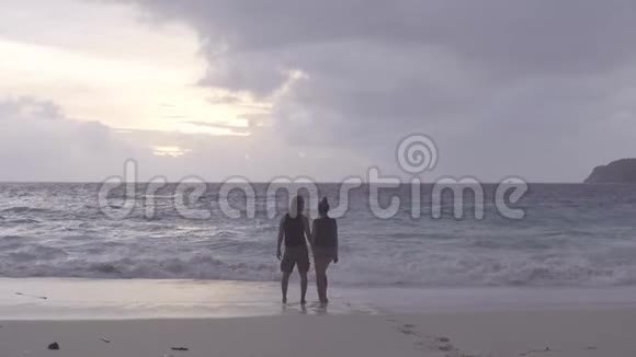 男人和女人站在海边看日落拥抱视频的预览图