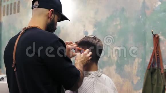年轻英俊的白种人在一家现代理发店理发用有胡须的电动装饰器造型视频的预览图