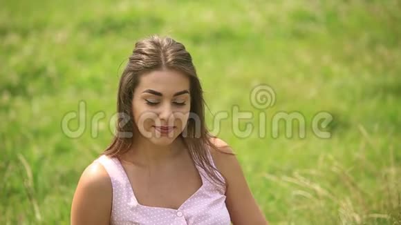 美丽的女士坐在草地上视频的预览图