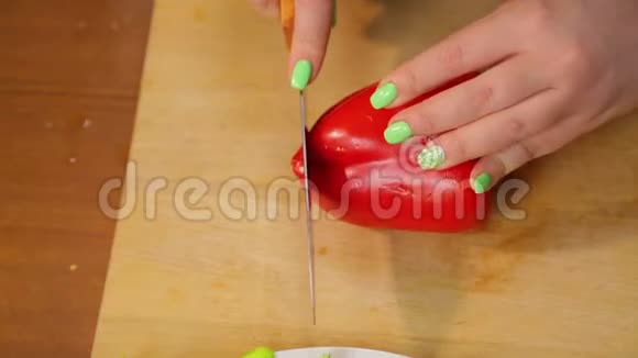女人用刀子在木板上切红胡椒视频的预览图