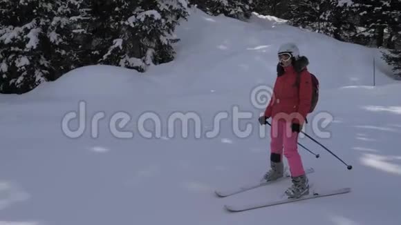 运动的年轻女子在阿尔卑斯山的山坡上滑雪视频的预览图