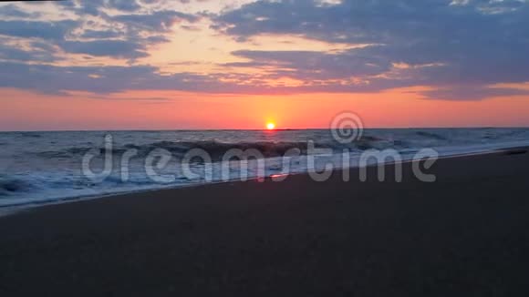 美丽的日落在海滩惊人的颜色光束照耀透过云景海景在日落海水25视频的预览图