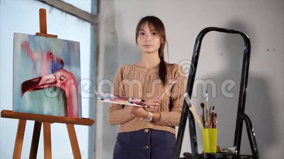 一位专业艺术家站在她画的粉红色火烈鸟旁边视频的预览图