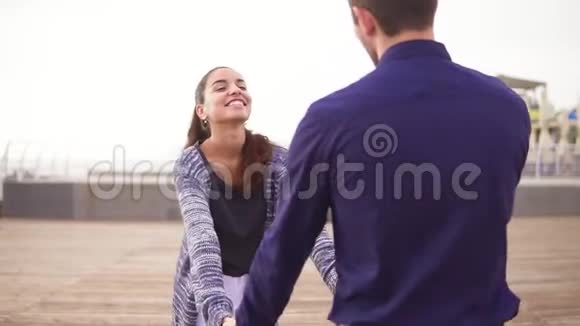 在海滩上一对年轻夫妇手牵着手一起散步看着眼睛开心地笑着视频的预览图