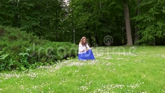 准妈妈在公园草地上采摘雏菊替身视频的预览图