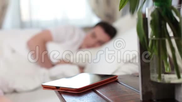 年轻人睡觉时女人从桌子上拿药片视频的预览图
