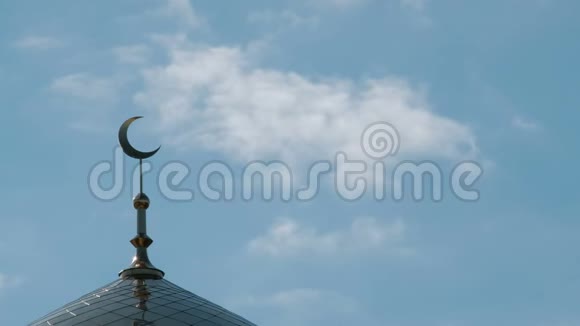穆斯林或伊斯兰宗教的象征云彩飘过清真寺尖塔顶部的金色月牙阳光明媚的一天视频的预览图