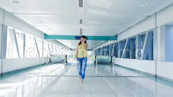 女人走在自动人行道上在地铁口用她的电话一种沟通的手段一种时尚视频的预览图