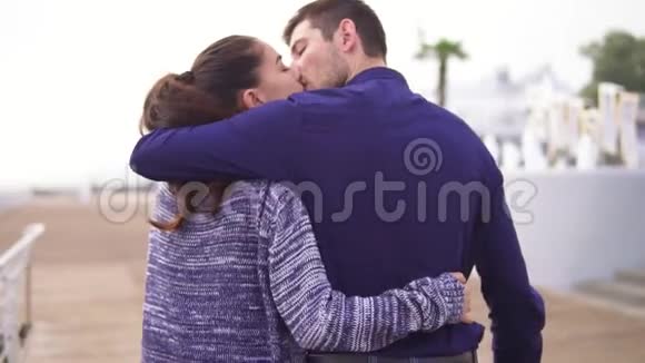 特写后景年轻漂亮的夫妇走在街上互相拥抱亲吻浪漫的约会视频的预览图
