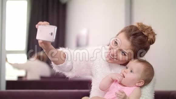 美丽的女人和婴儿一起自拍母亲带着孩子拍照视频的预览图