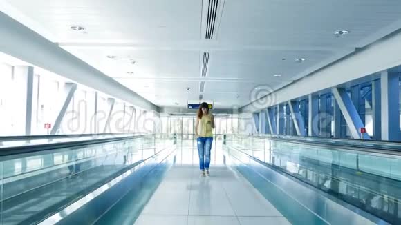 女人走在自动人行道上在地铁口用她的电话一种沟通的手段一种时尚视频的预览图