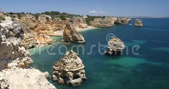 天然洞穴在马林哈海滩阿尔加维葡萄牙Marinha海滩的岩石悬崖拱门和葡萄牙海岸的绿松石海水视频的预览图