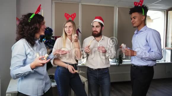 多种族的快乐上班族在圣诞节期间拿着酒杯喝着起泡酒边吃零食边聊天视频的预览图