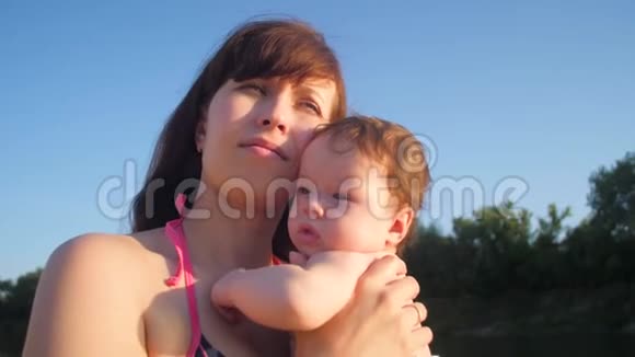 妈妈吻婴儿对着蓝天视频的预览图