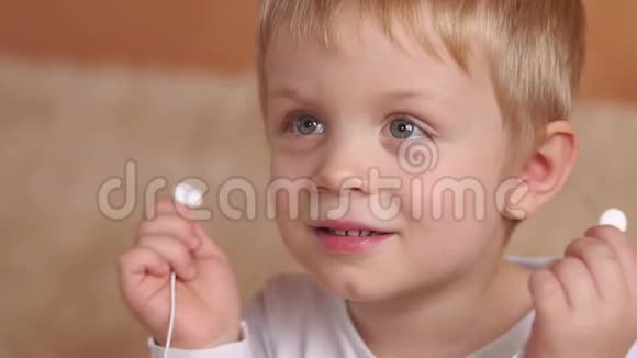 戴着耳机的小男孩的脸部特写视频的预览图
