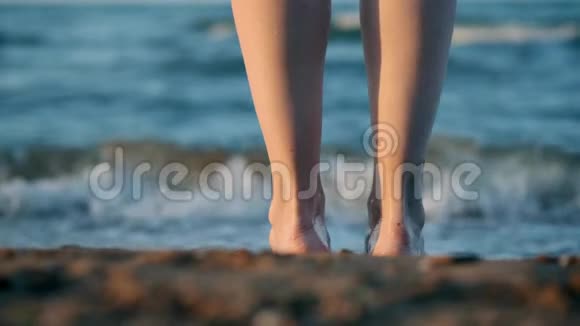 向下移动关闭女性或女孩的脚踩在贝壳上的黄沙上进入大海女孩陷入了视频的预览图