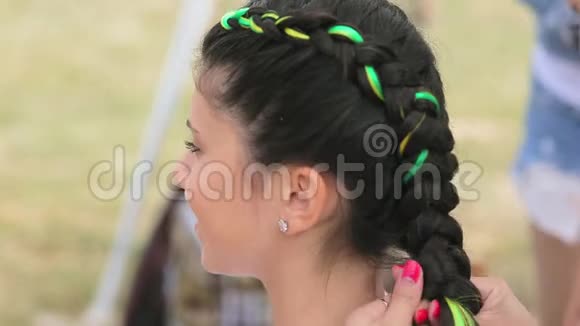 理发师把明亮的卡恩卡隆编织进街上女孩的辫子里视频的预览图