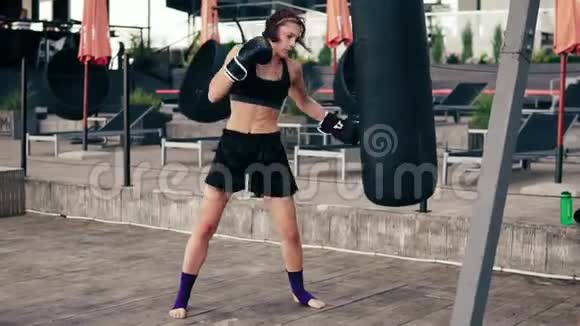 高节奏视频强壮的运动女拳击手戴手套带着一个袋子锻炼她用腿打了个包工作安排视频的预览图