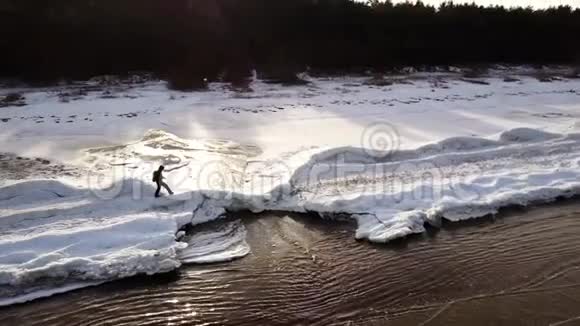 空中飞行在冰冻的海滨覆盖着雪其中一个人正沿着它走视频的预览图