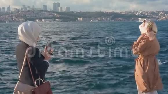 两名穆斯林妇女在伊斯坦布尔市背景下拍照视频的预览图