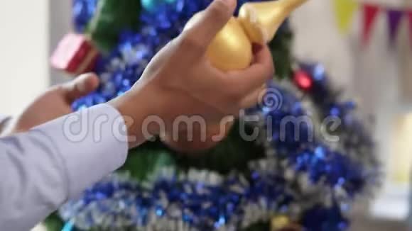一只非裔美国人的手在一棵小小的人造圣诞树上装饰的特写镜头视频的预览图