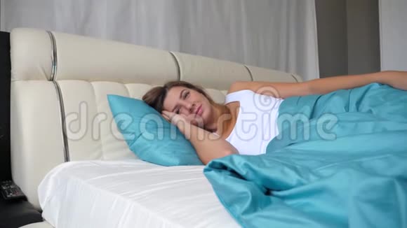 白种人女人在早晨醒来在房间里解冻在床上逗留视频的预览图