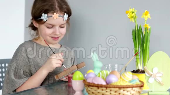 一个漂亮的女孩画了古奇复活节快乐准备假期孩子们创造力复活节兔子春天视频的预览图