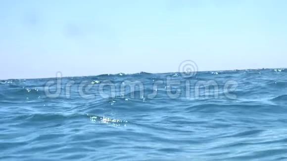 海浪在蓝色的海洋中缓慢运动相机在海洋中摆动然后进入水下视频的预览图
