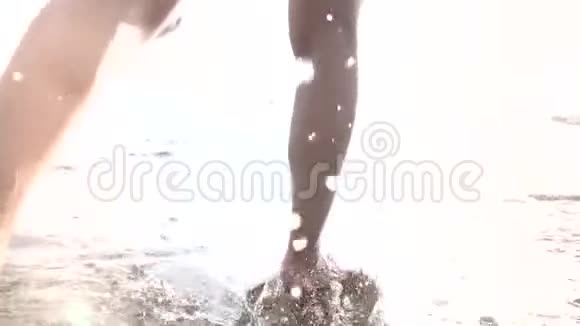 穿裙子的女孩在沙滩上沿着冲浪线奔跑视频的预览图