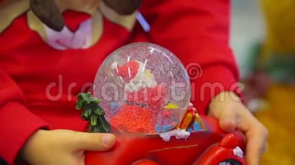 寒假男孩抱着一辆小红车怀里抱着雪球摇着它视频的预览图