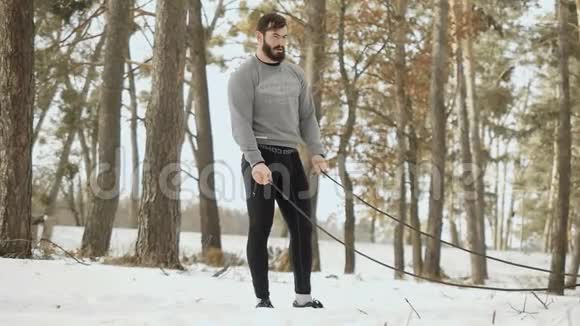 肌肉男在冬季森林里用绳子休息视频的预览图