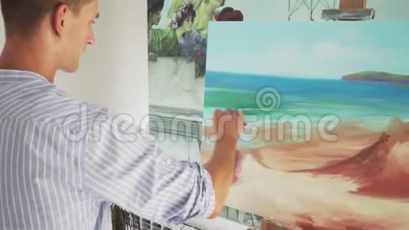 男画家在画布上画风景视频的预览图