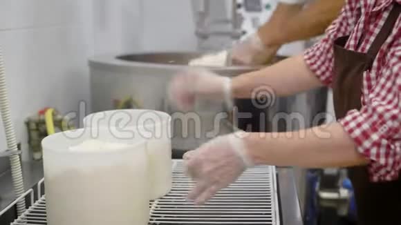 一家奶酪制作工厂的员工把奶酪豆腐放进塑料桶里视频的预览图