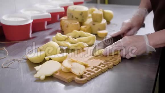 奶酪工厂的工人用一把带特殊手套的刀切新鲜奶酪视频的预览图