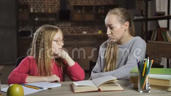 无聊的女孩不愿和妈妈做家庭作业视频的预览图