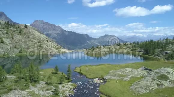 在阳光明媚的夏日在清澈的蓝色湖泊和松树林之上向前迈进欧洲意大利阿尔卑斯山山谷奥斯塔户外绿色视频的预览图