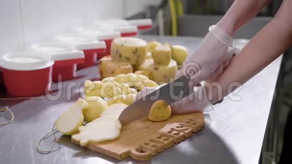 一个奶酪制作工厂工人在切割板上切奶酪的特写镜头视频的预览图