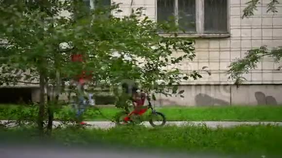 夏天妈妈和儿子骑着自行车在户外散步慢动作视频的预览图