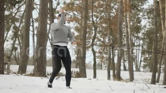 运动员用绳子训练冬季森林中的肌肉视频的预览图