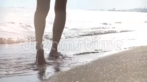 在沙滩上日落时女孩在海浪中奔跑幸福的概念视频的预览图