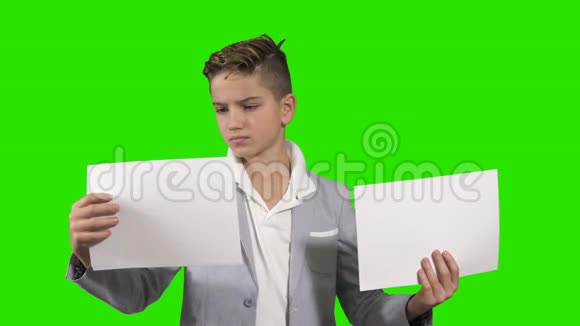 Glomy青少年在绿色背景下拿着两份文件视频的预览图