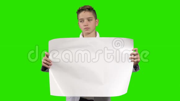 少年在绿色背景下拿着一张空纸视频的预览图