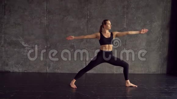 一个漂亮聪明运动的女孩在阁楼风格的健身房里做瑜伽练习从大窗户发出自然光她是视频的预览图