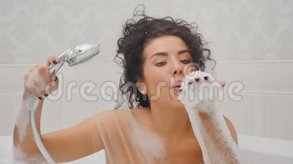 女人玩得很开心用慢动作在浴室里吹泡沫视频的预览图