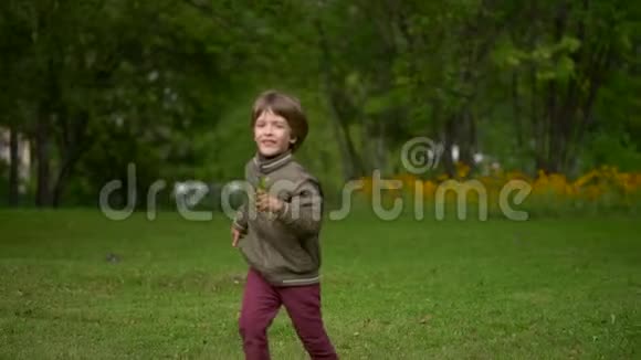 一个年轻快乐的男孩夏天在户外跑步慢动作视频的预览图