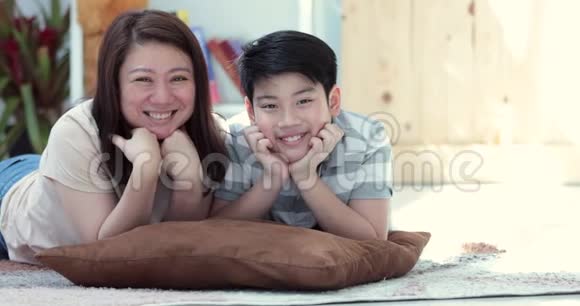 亚洲家庭的母亲和儿子一起看镜头一起在你脸上表演的肖像视频的预览图