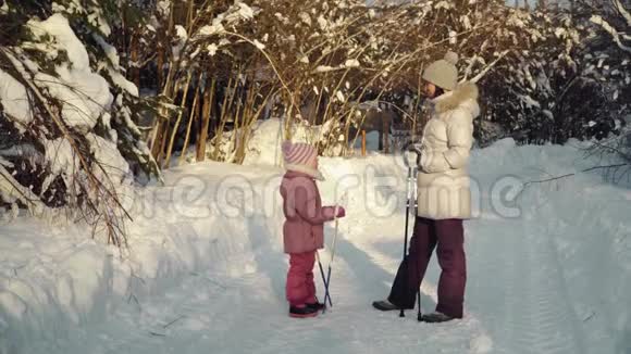 妈妈和女儿在冬天北欧人在郊区散步之前交谈视频的预览图